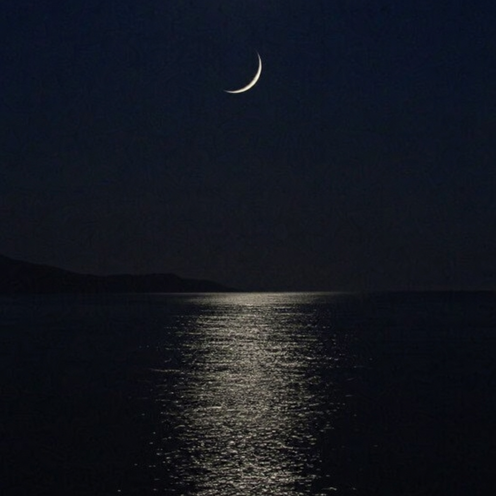 Tranquil scene of a new moon night reflecting on calm waters, creating the perfect setting for bioluminescent kayaking.